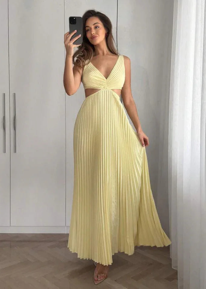 Femme portant une robe longue plissée jaune pâle à décolleté et découpes, selfie en intérieur