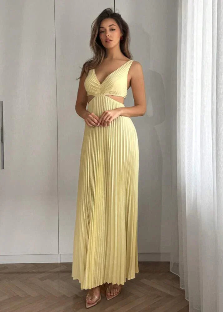 Femme portant une robe longue plissée jaune pâle avec découpe à la taille, style élégant