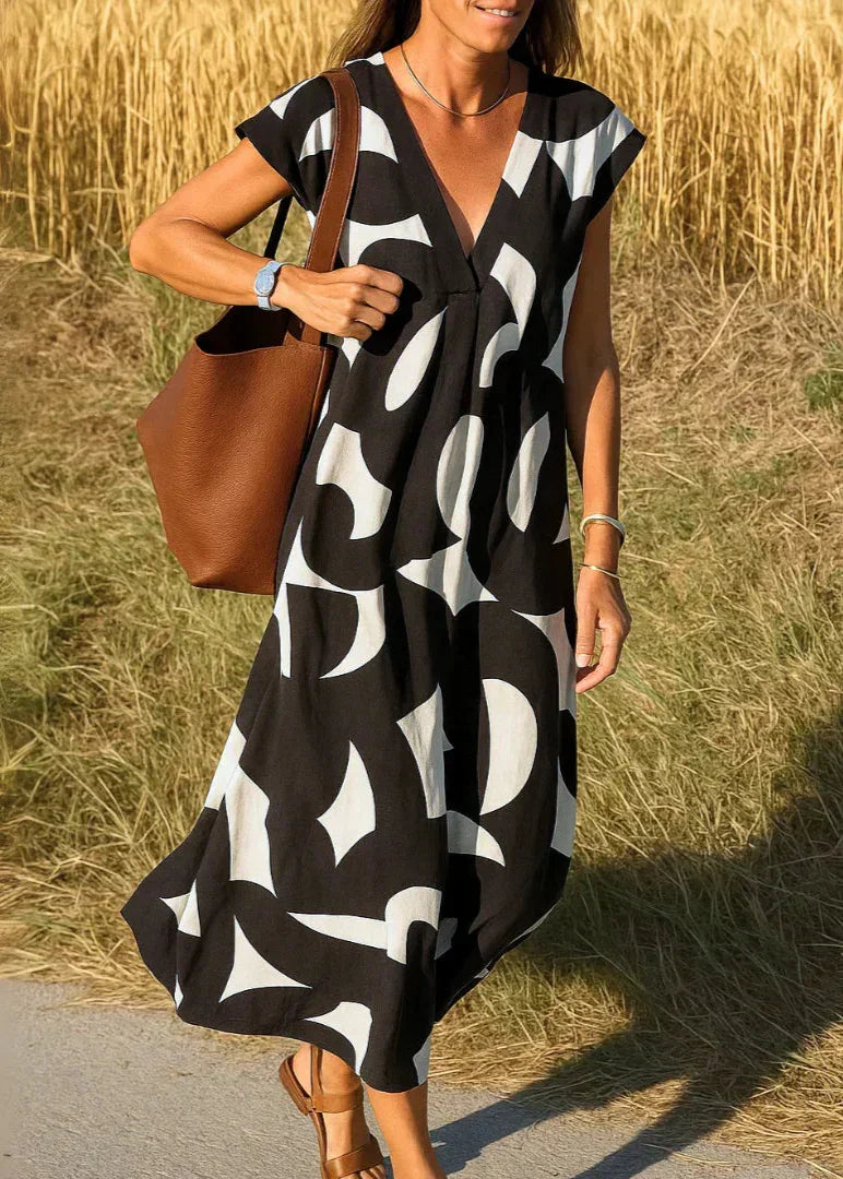 Robe longue noire à motifs blancs géométriques, portée en été avec sac marron
