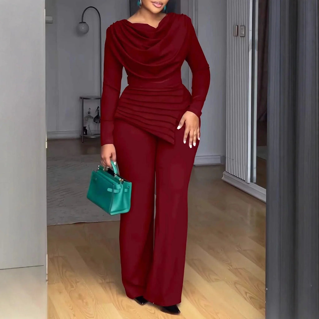 Femme portant un ensemble élégant bordeaux manches longues, pantalon large, sac à main vert