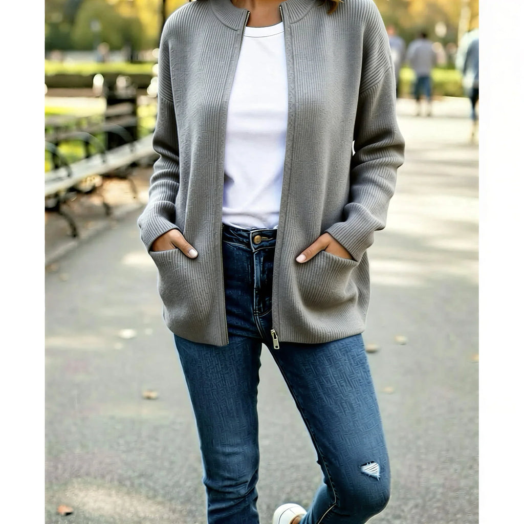 Femme portant un cardigan gris et jean déchiré, mode décontractée en extérieur