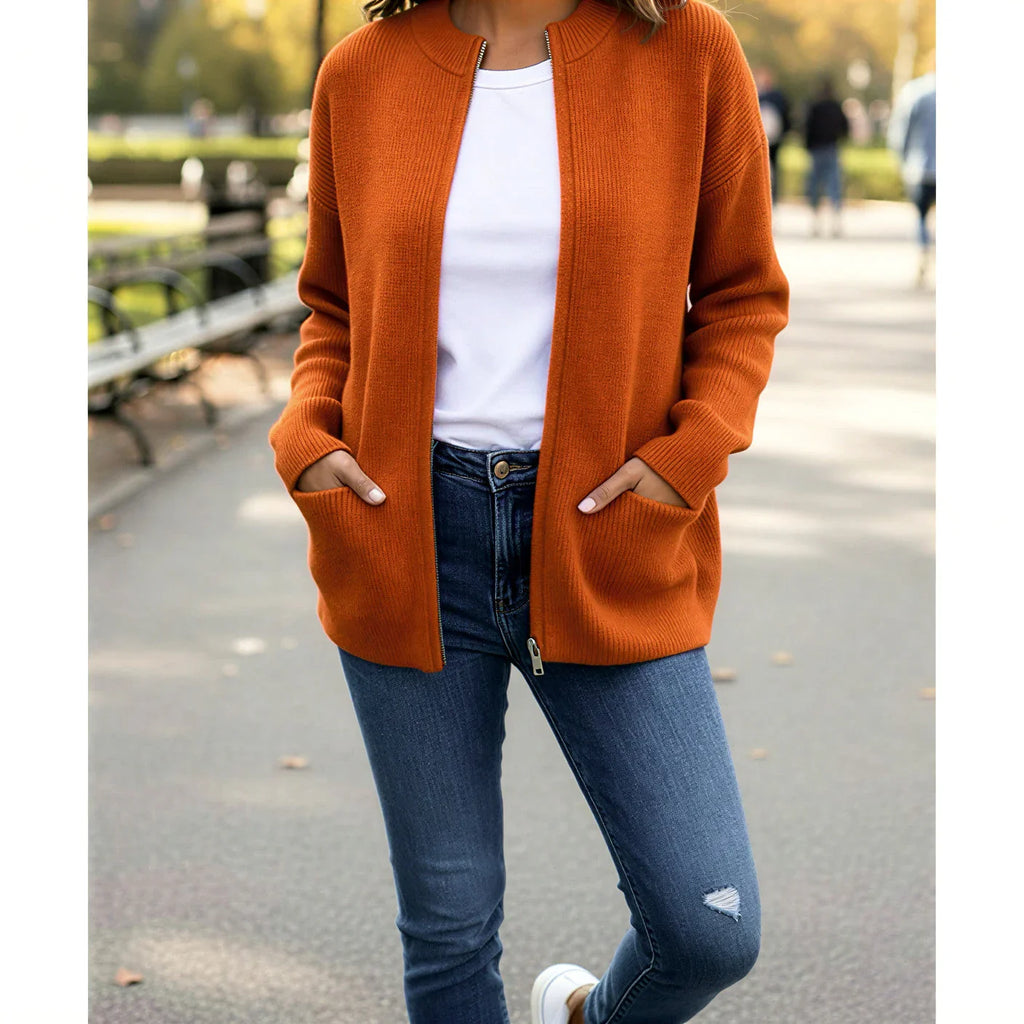 Femme portant un cardigan orange en maille, t-shirt blanc et jean bleu, mode automne
