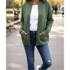 Femme portant un gilet vert en maille avec poches, t-shirt blanc et jean, promenade en parc