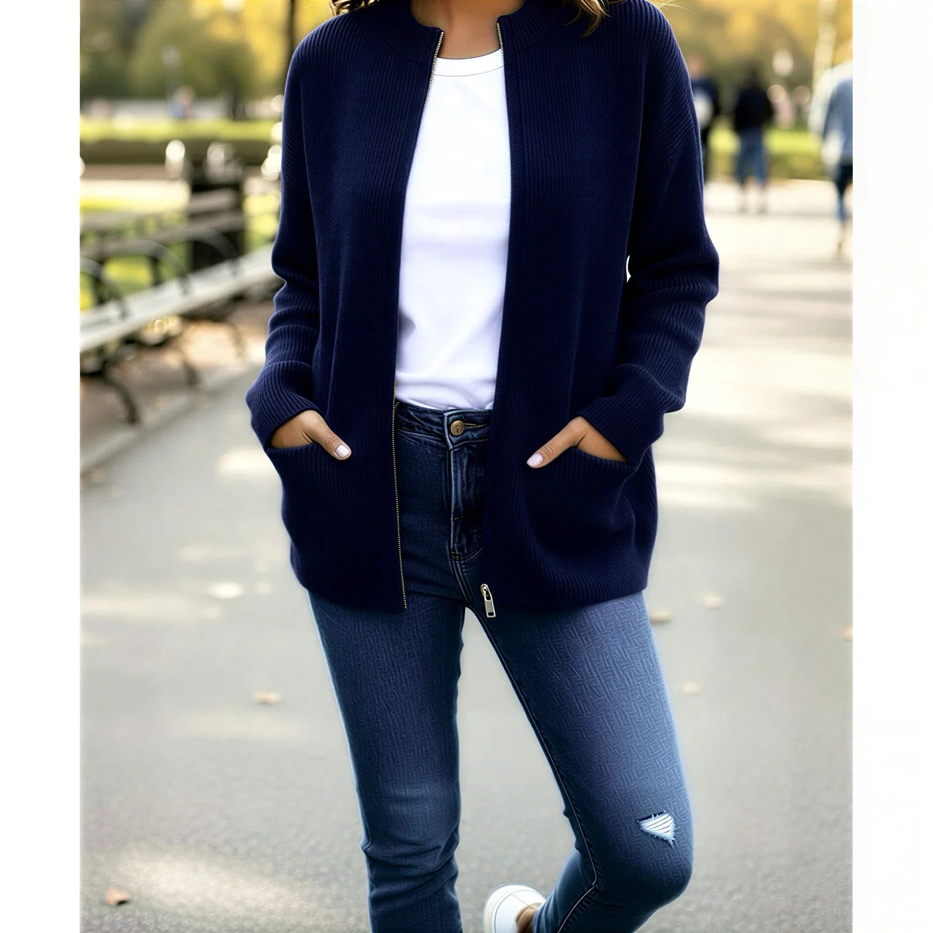 Femme portant un cardigan bleu marine, t-shirt blanc et jean, look décontracté en extérieur