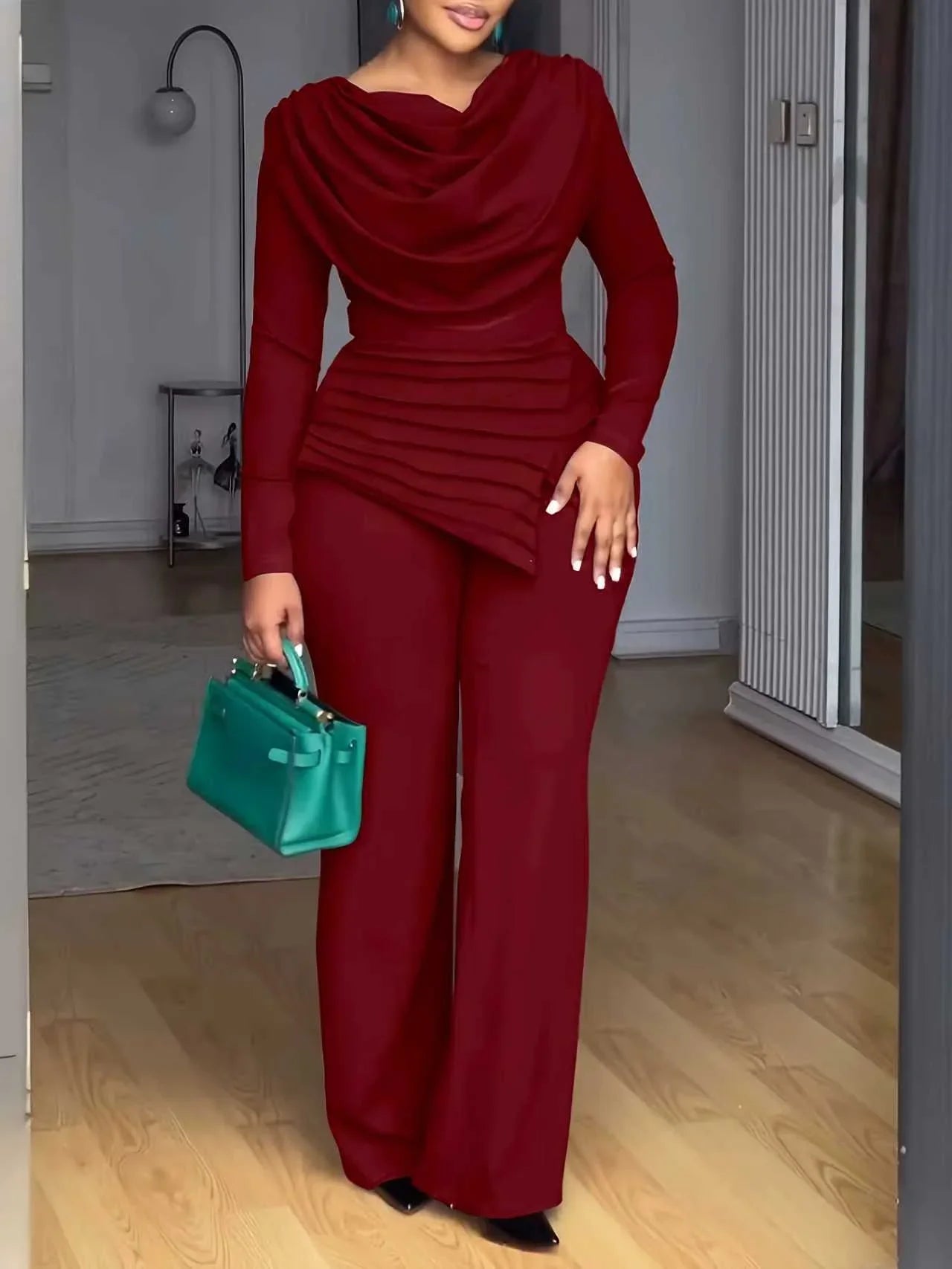 Femme en combinaison pantalon rouge élégante, sac à main vert, mode chic intérieur