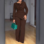 Femme portant une combinaison marron élégante avec un sac à main vert, intérieur moderne